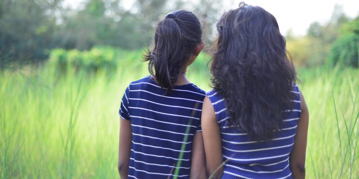 Image of sisters in rural setting.