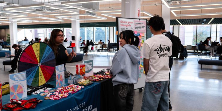 Students at the feedback hub in the Library.