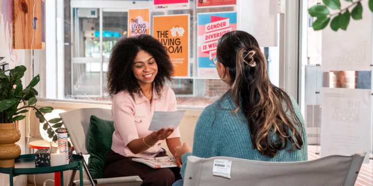 Two students talking in the Living Room.