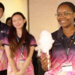 Student holding fairy floss in front of two other students on campus.