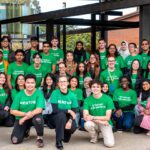 Group of Curtin student volunteers wearing green “Student Volunteer” shirts, posing together on campus.