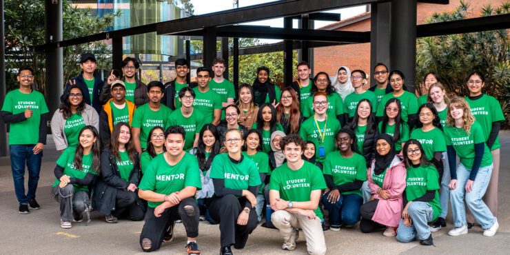 Group of 911������ student volunteers wearing green “Student Volunteer” shirts, posing together on campus.