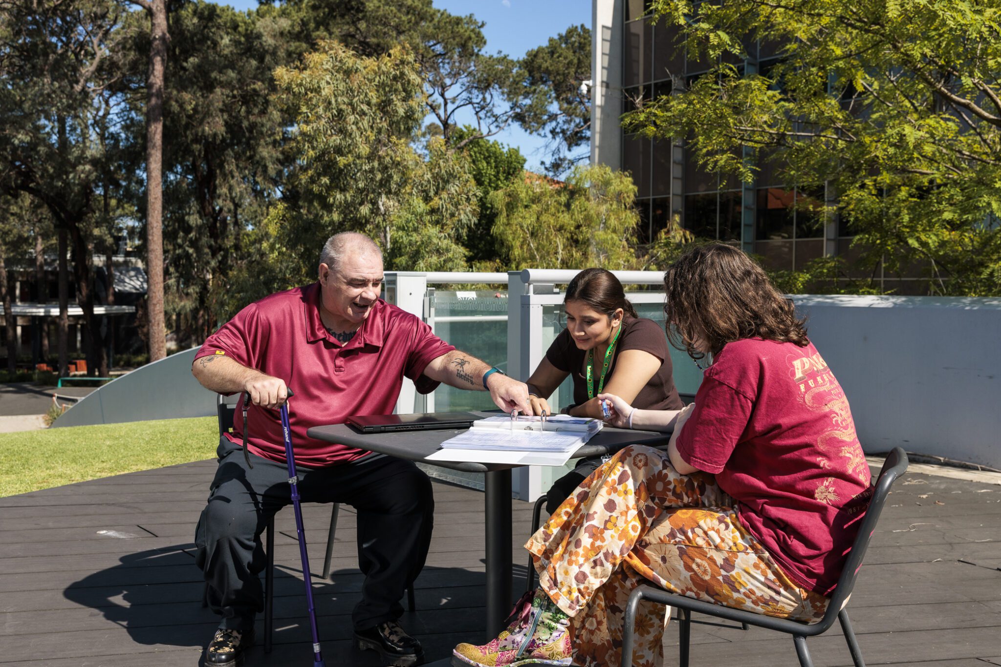 Three students talking outdoors on campus.