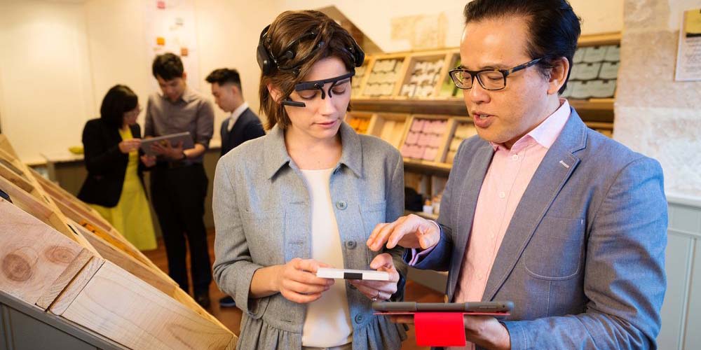 A researcher setting up consumer research biometric tracking equipment on a participant in the consumer research lab