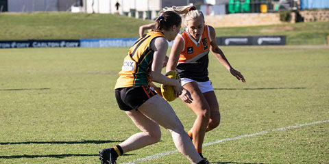 A Curtin women's footballer blocks the path of a rival player during a game