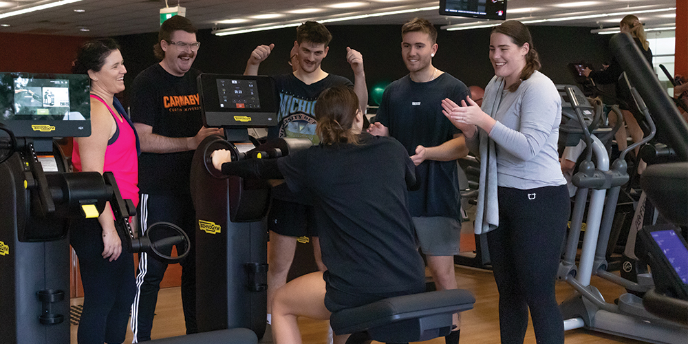 Gym members cheer on a member who is training