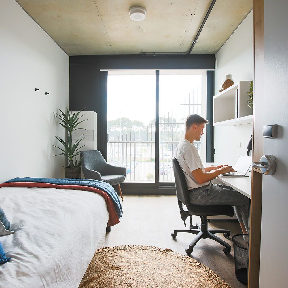 Man sitting in desk of a bedroom