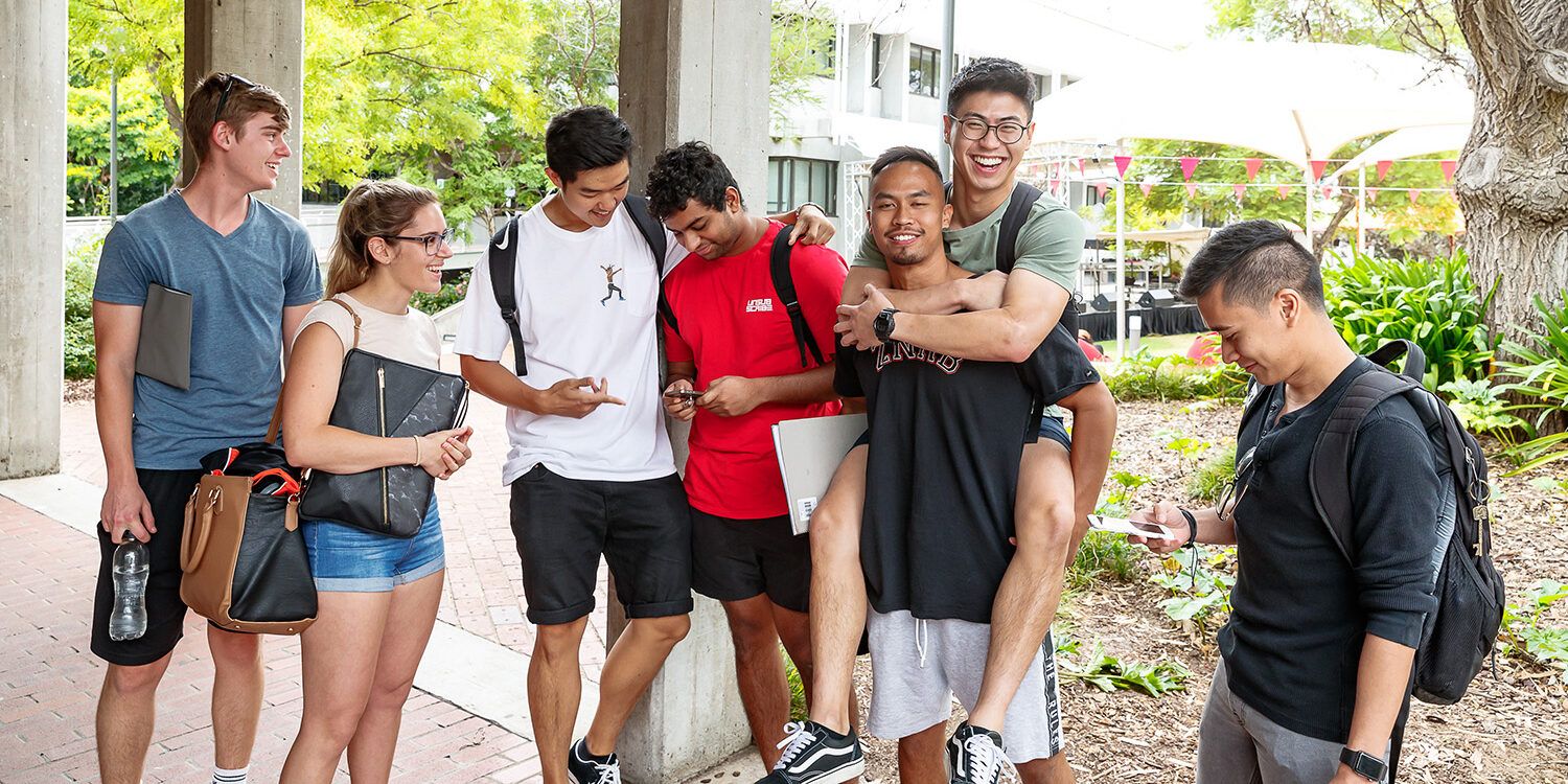 Nine students all standing up and being casual