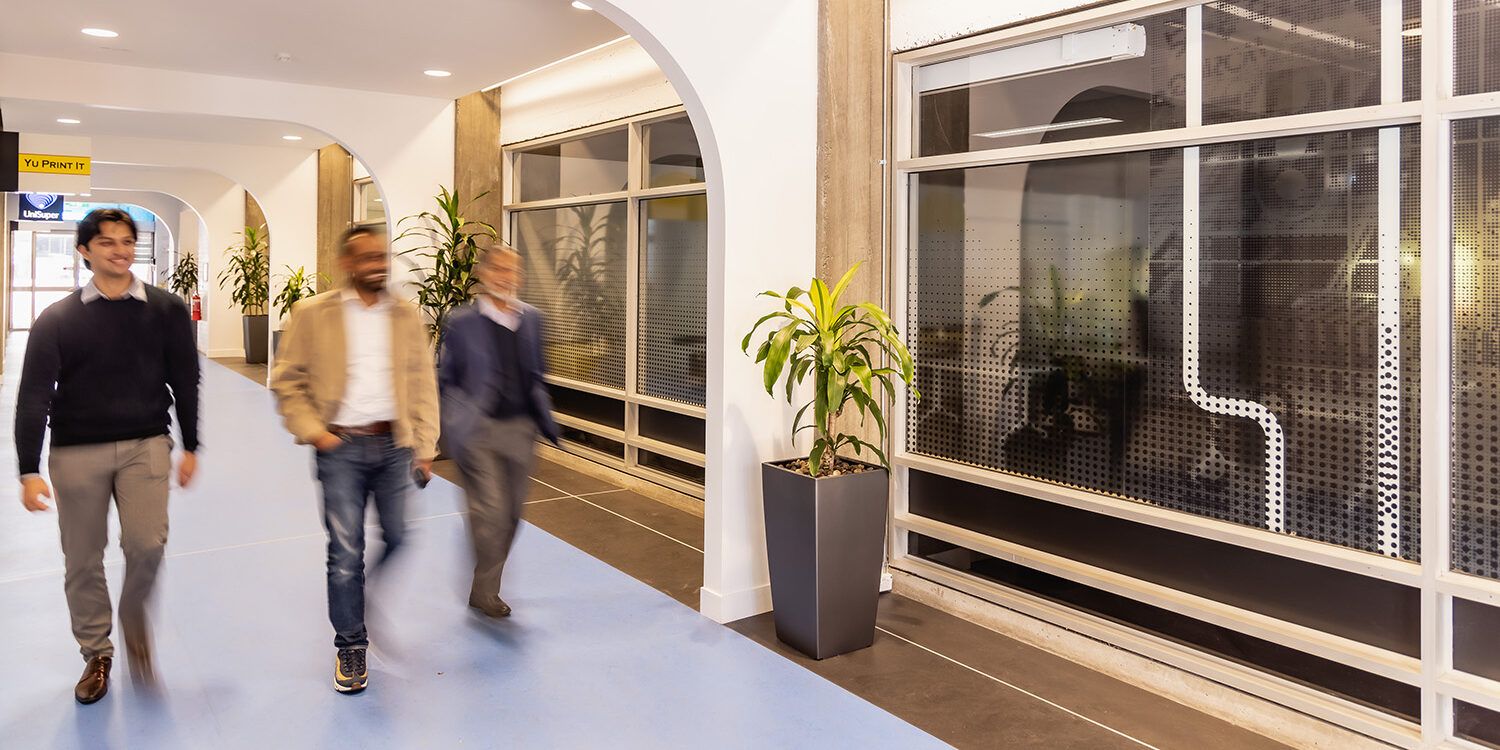 Three people walking down corridor