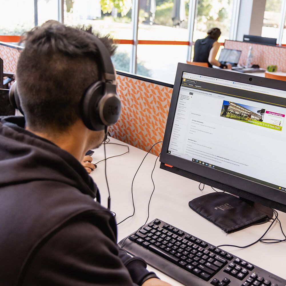 Man on computer with headphones