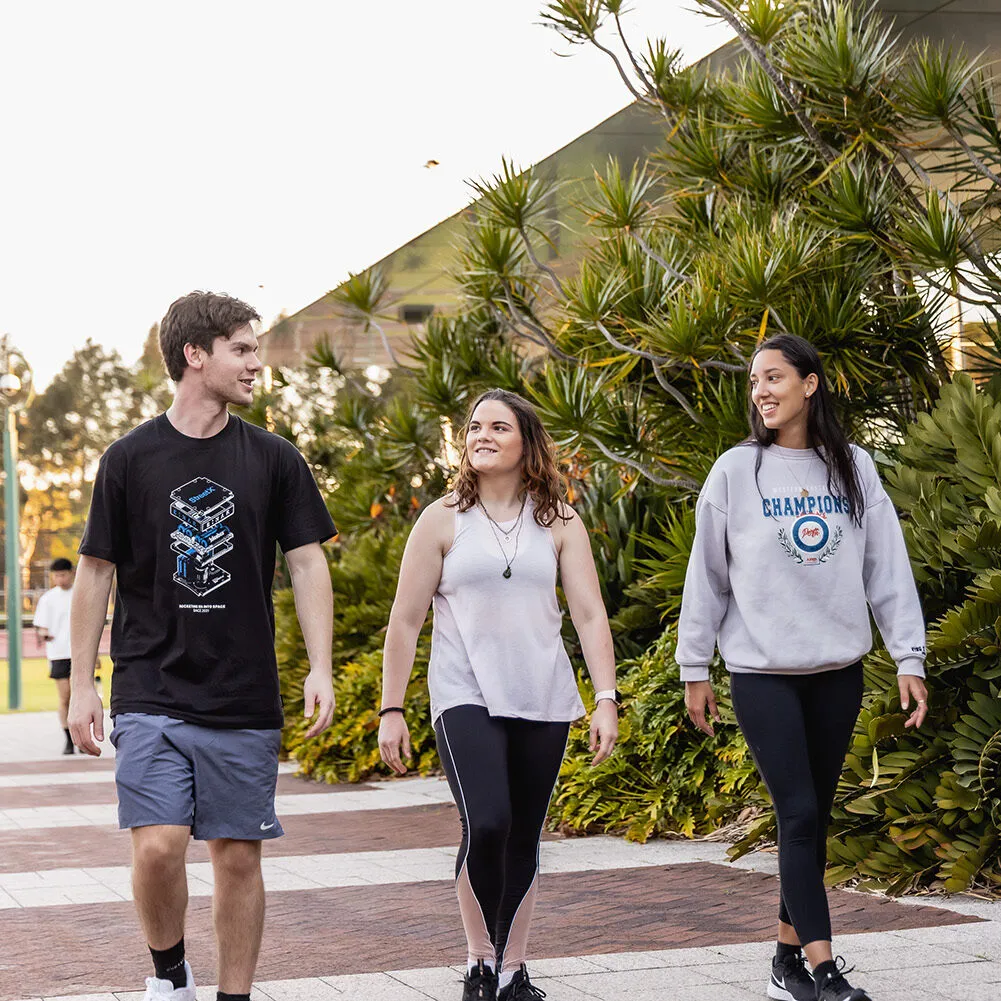 3 students walking next to the Curtin gym