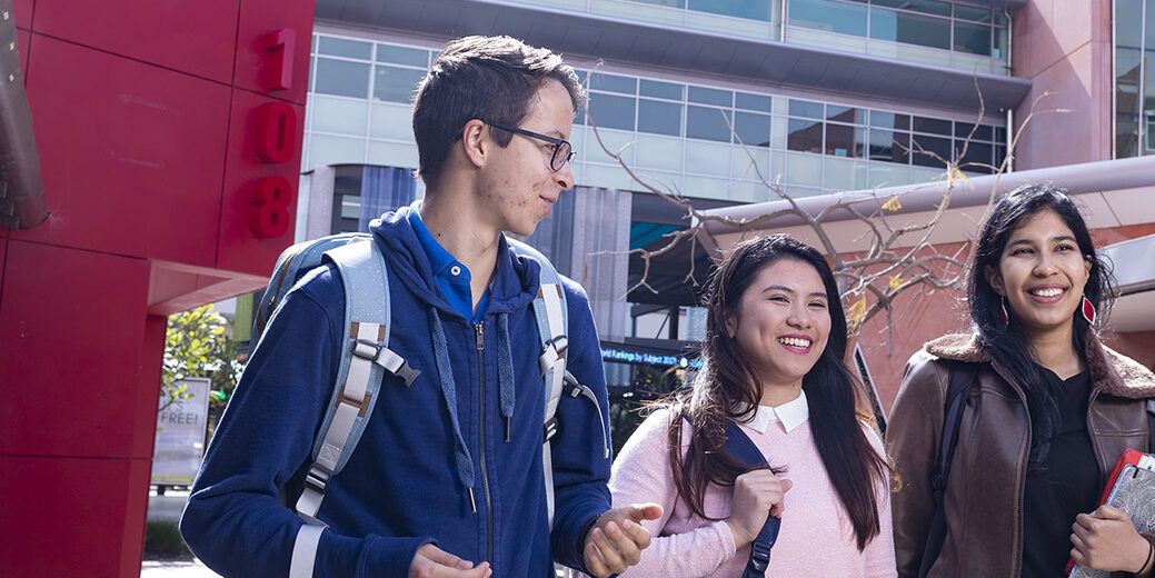 Three students walking outdoors