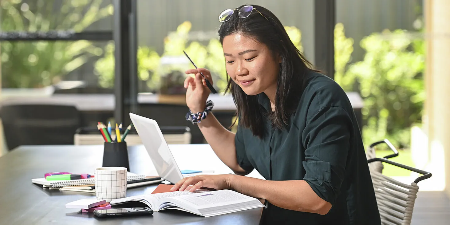 Person reading a book and taking notes