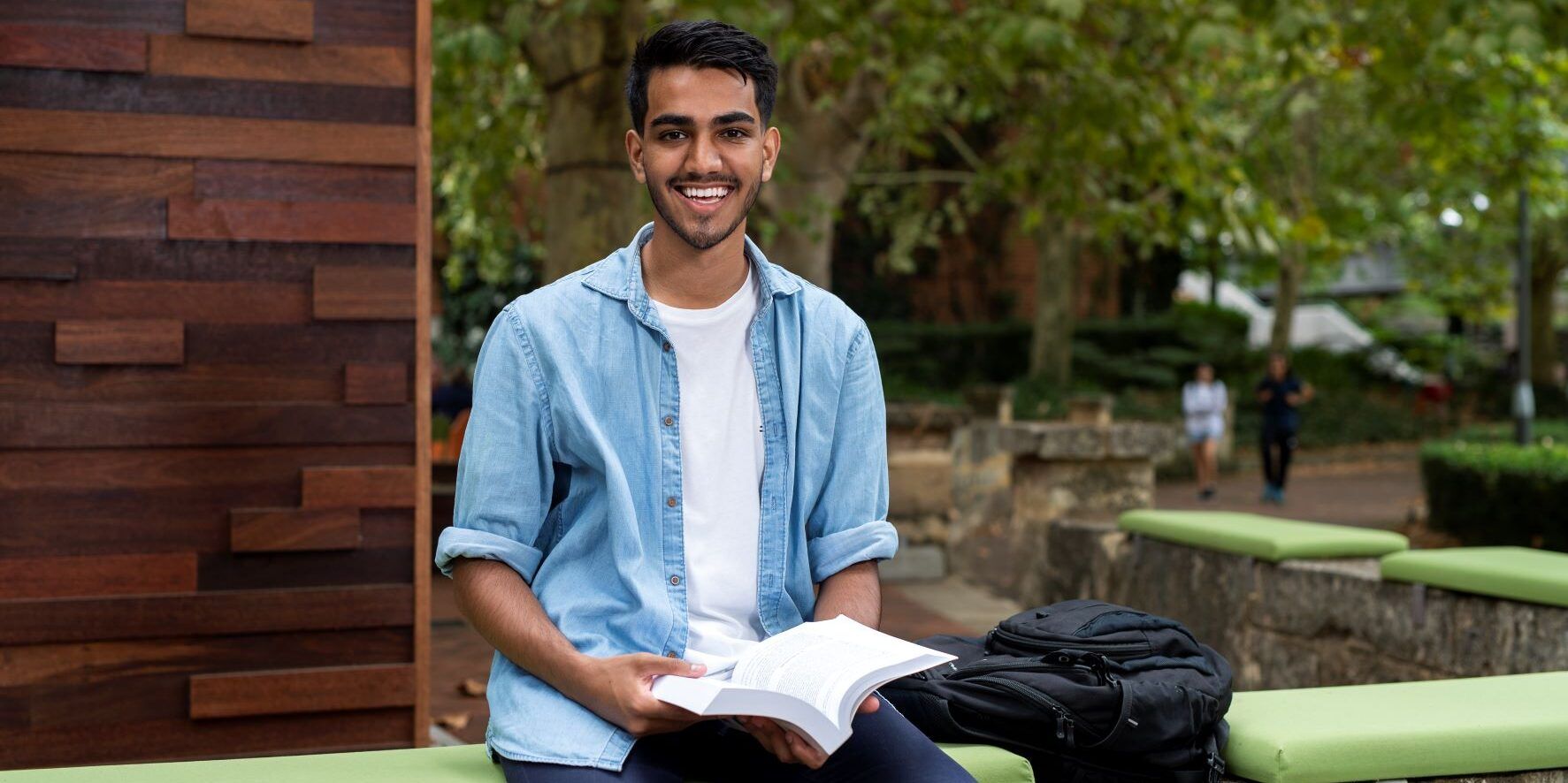 Man looking at a book outdoors