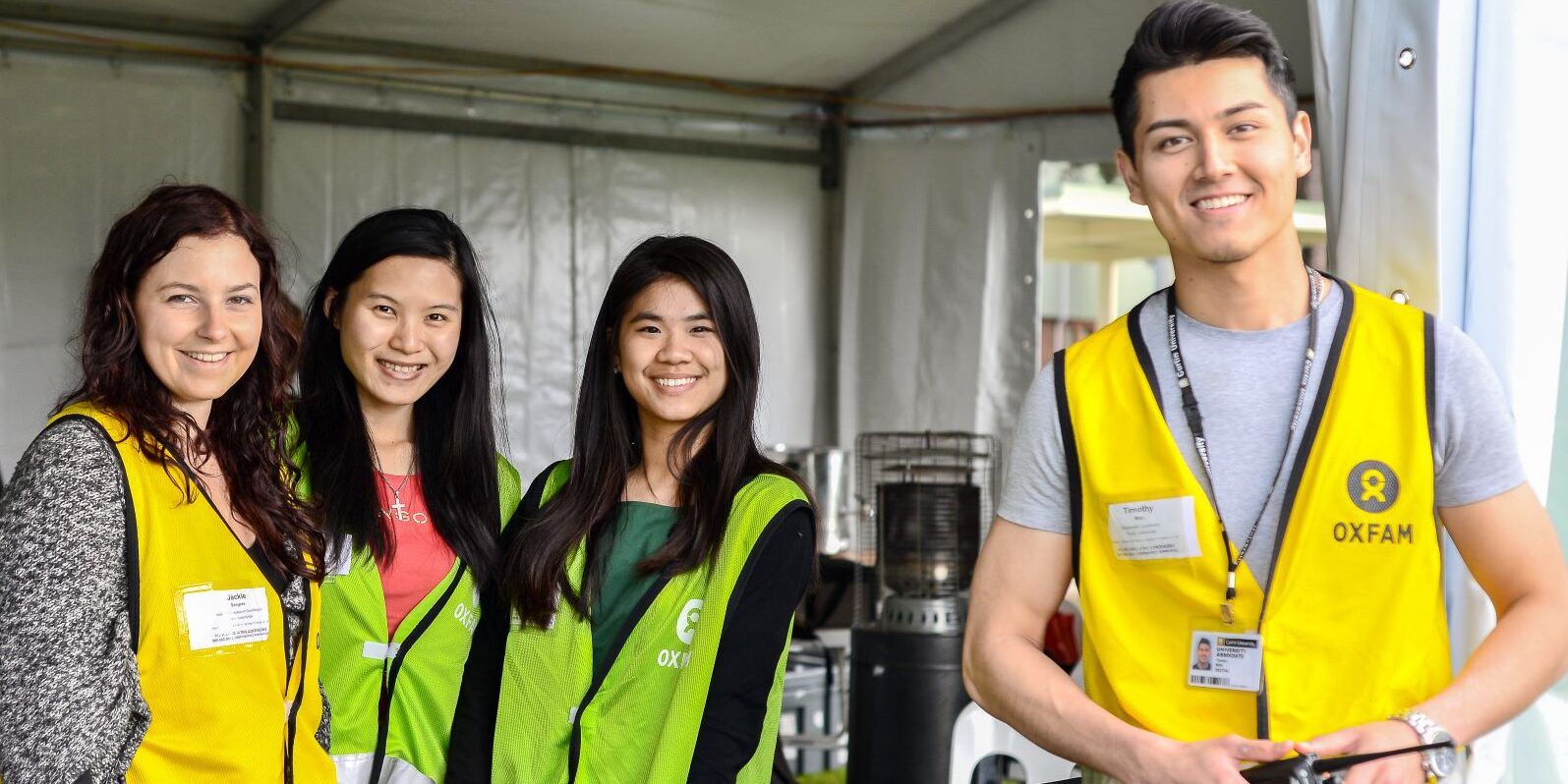 Four people with high vis facing the camera in a marquee tent