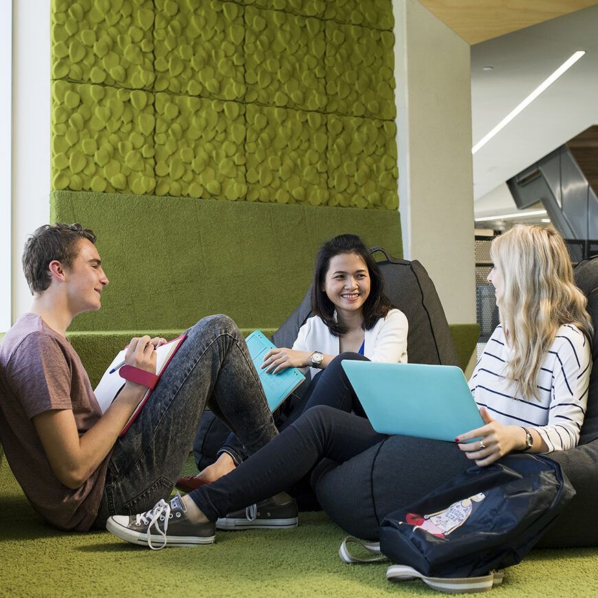 Three students discussing whilst sitting on bean bags