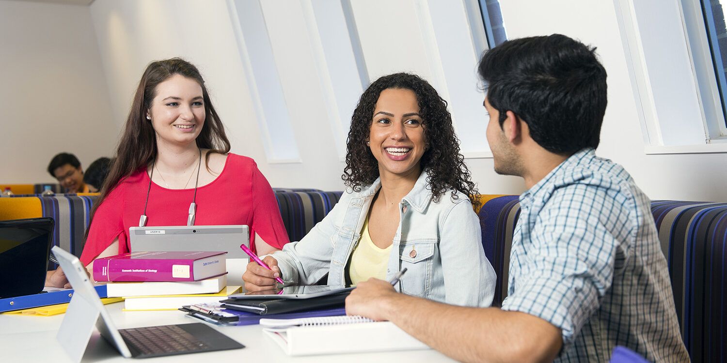 Three students studying at the library