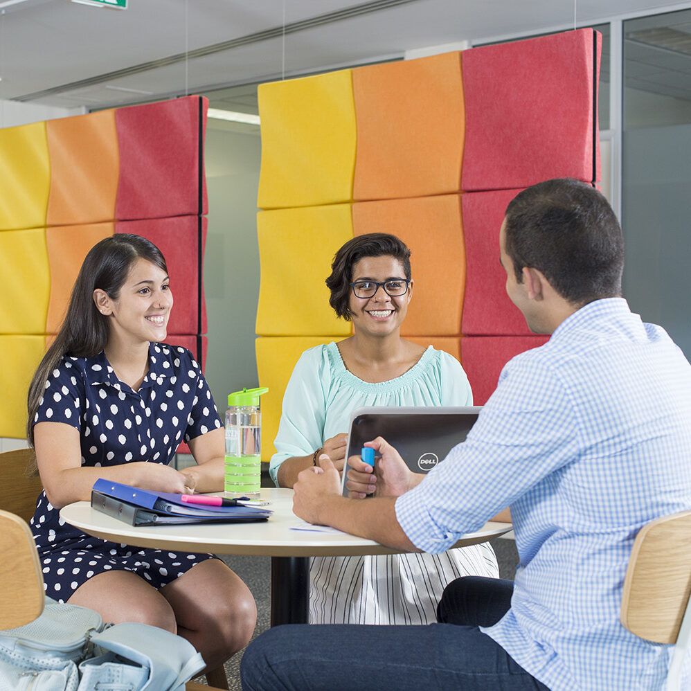 Three people sitting and discussing at table