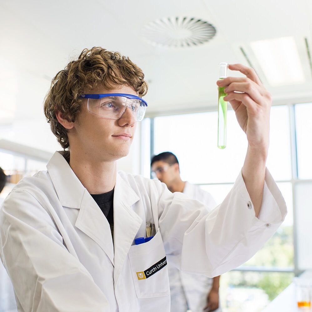 Man looking intensely at a green test tube