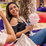 Student sits on a beanbag eating pink fairy floss