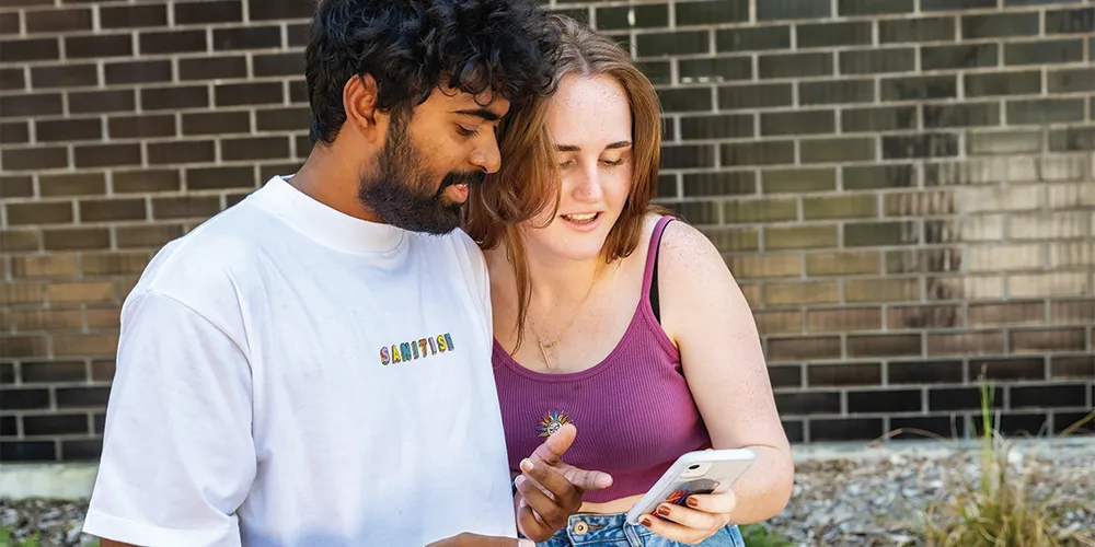 Two students looking at a mobile phone