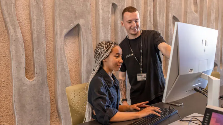 A Curtin Connect concierge helping a student on a computer