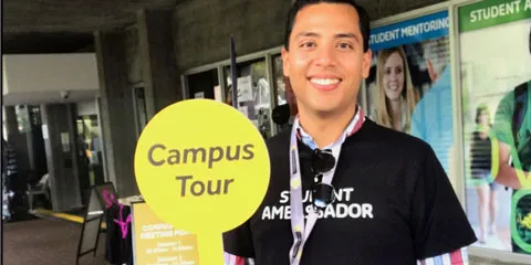 Student Ambassador holding up a sign that says: Campus Tour.
