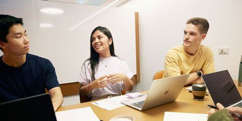 Three students sitting around a table.