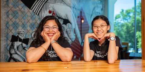 Two students smiling at the camera.