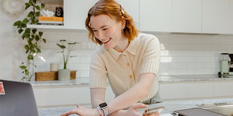 A female student similing and looking at her laptop