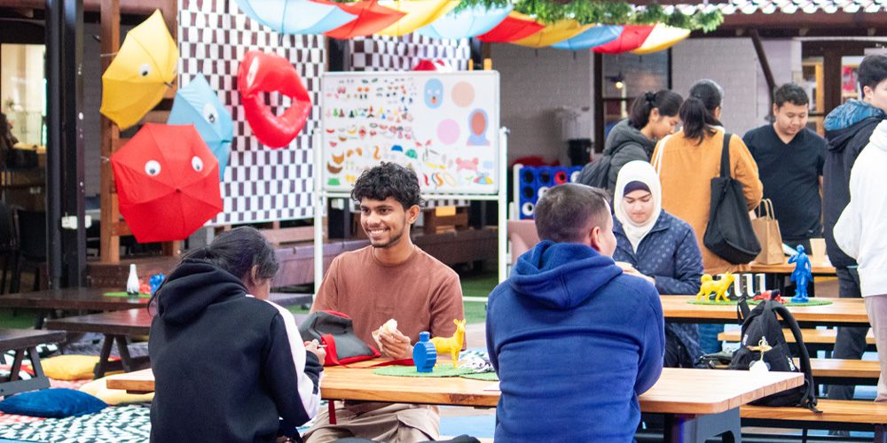 A group of students sitting at a table and smiling.