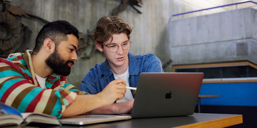 Two people looking at a laptop.