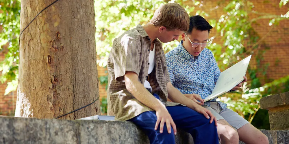 Two people looking at a workbook,