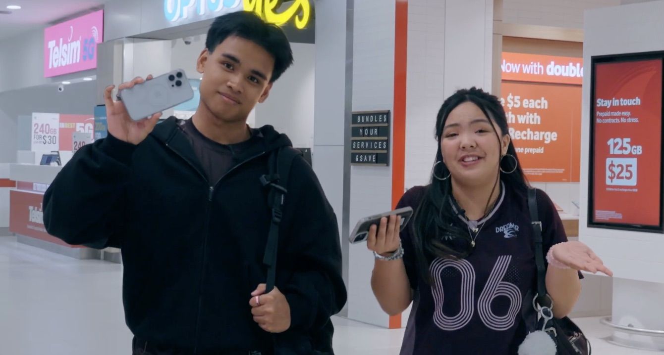 Image of Kristel and Musa holding their phones at the airport - play video