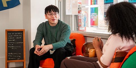 A peer support advisor talking to a student in the Living Room.