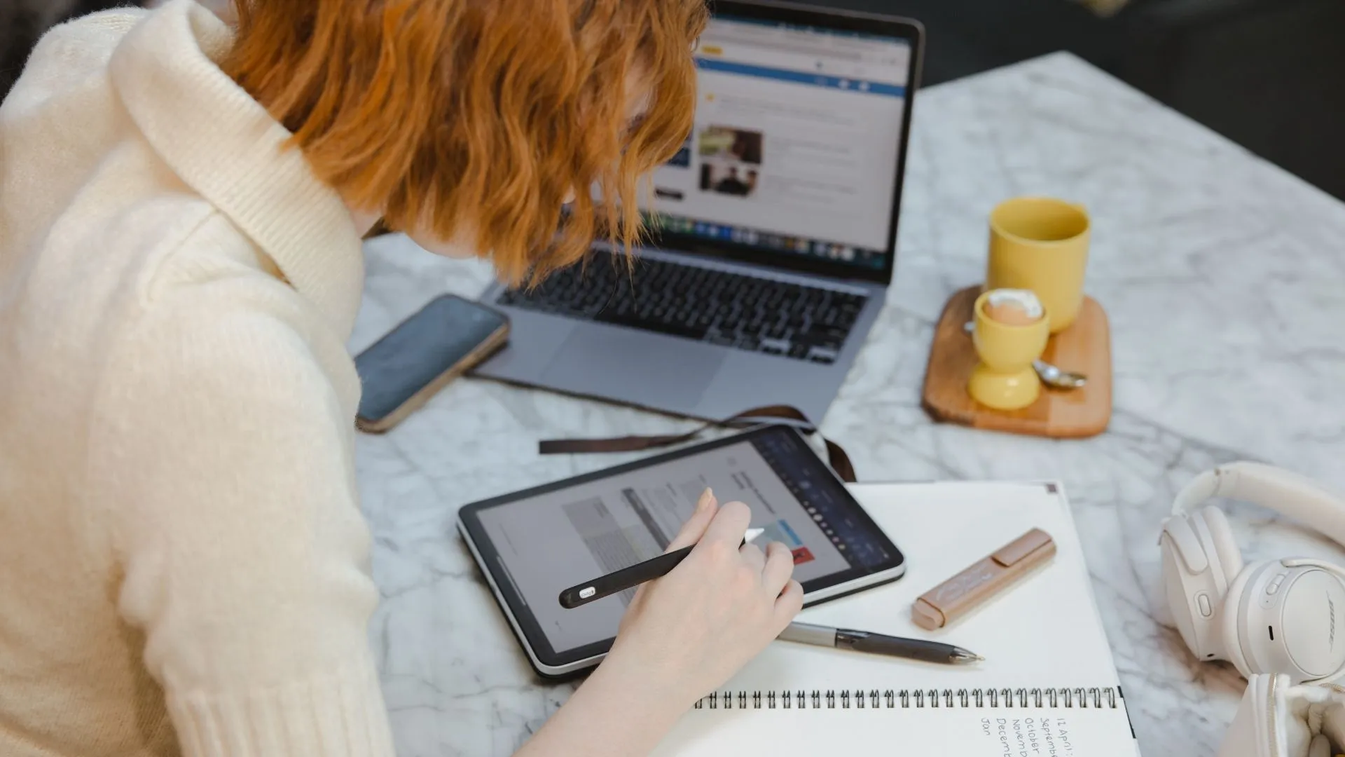 A person using a tablet and a laptop