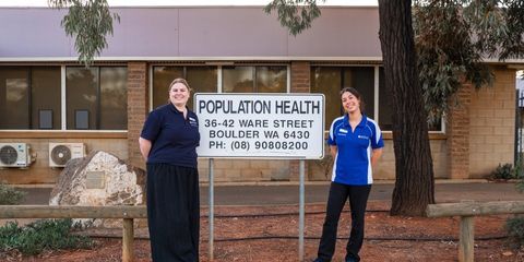 Population Health Students standing by a sign that reads 'Population Health'