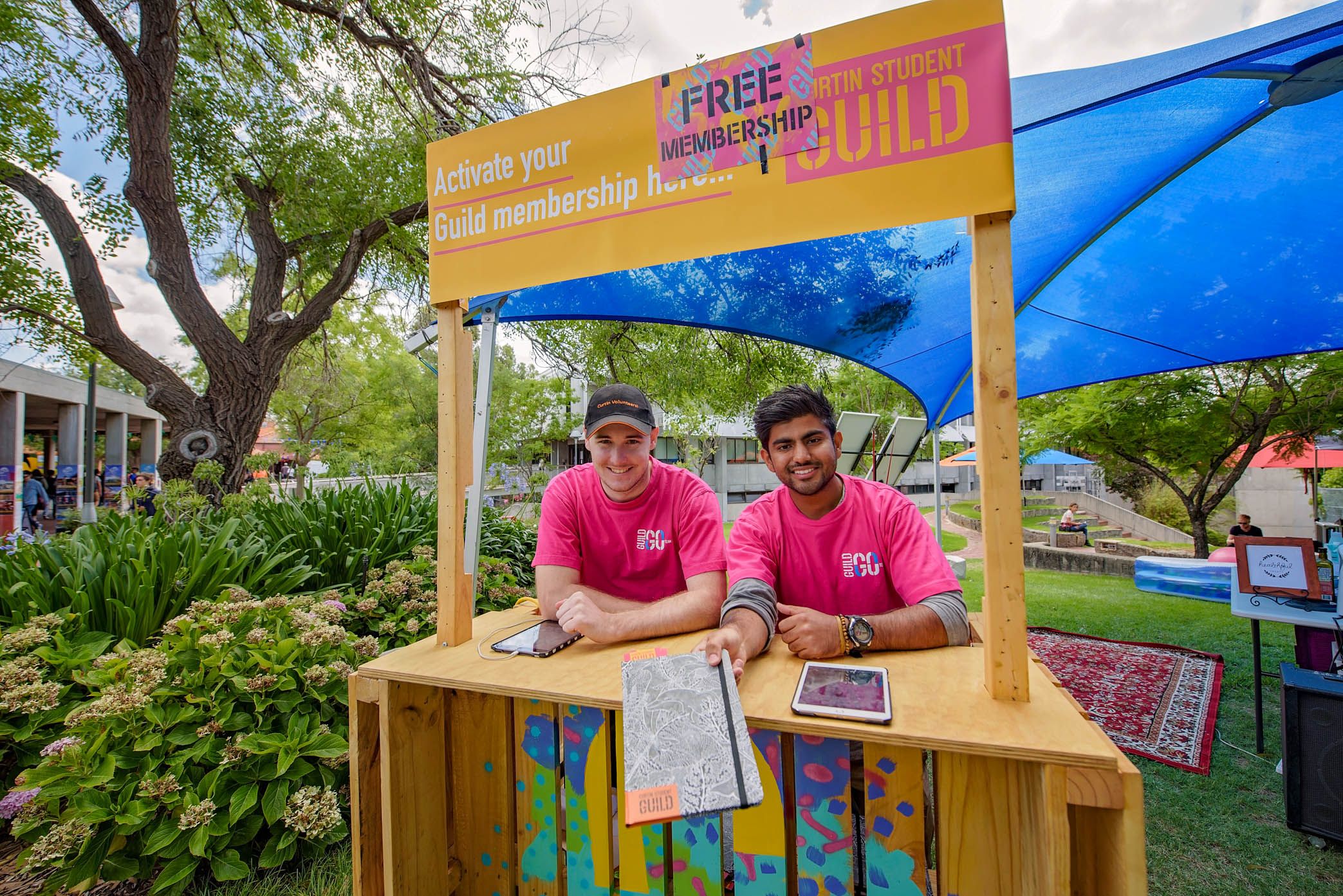 Two male students working at the Curtin Student Guild stand at Orientation Week