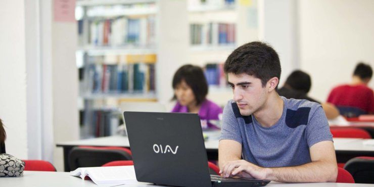 Man in blue tshirt on his laptop