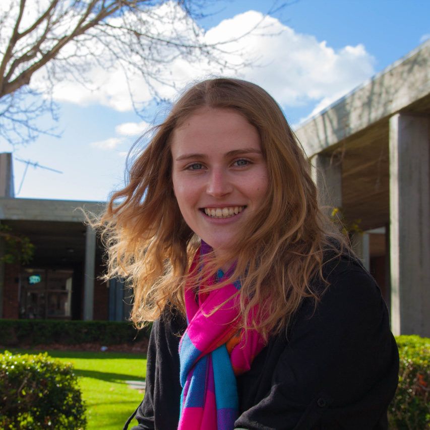 Curtin student, Jade Weary sitting in the grounds at Curtin, looking at camera and smiling