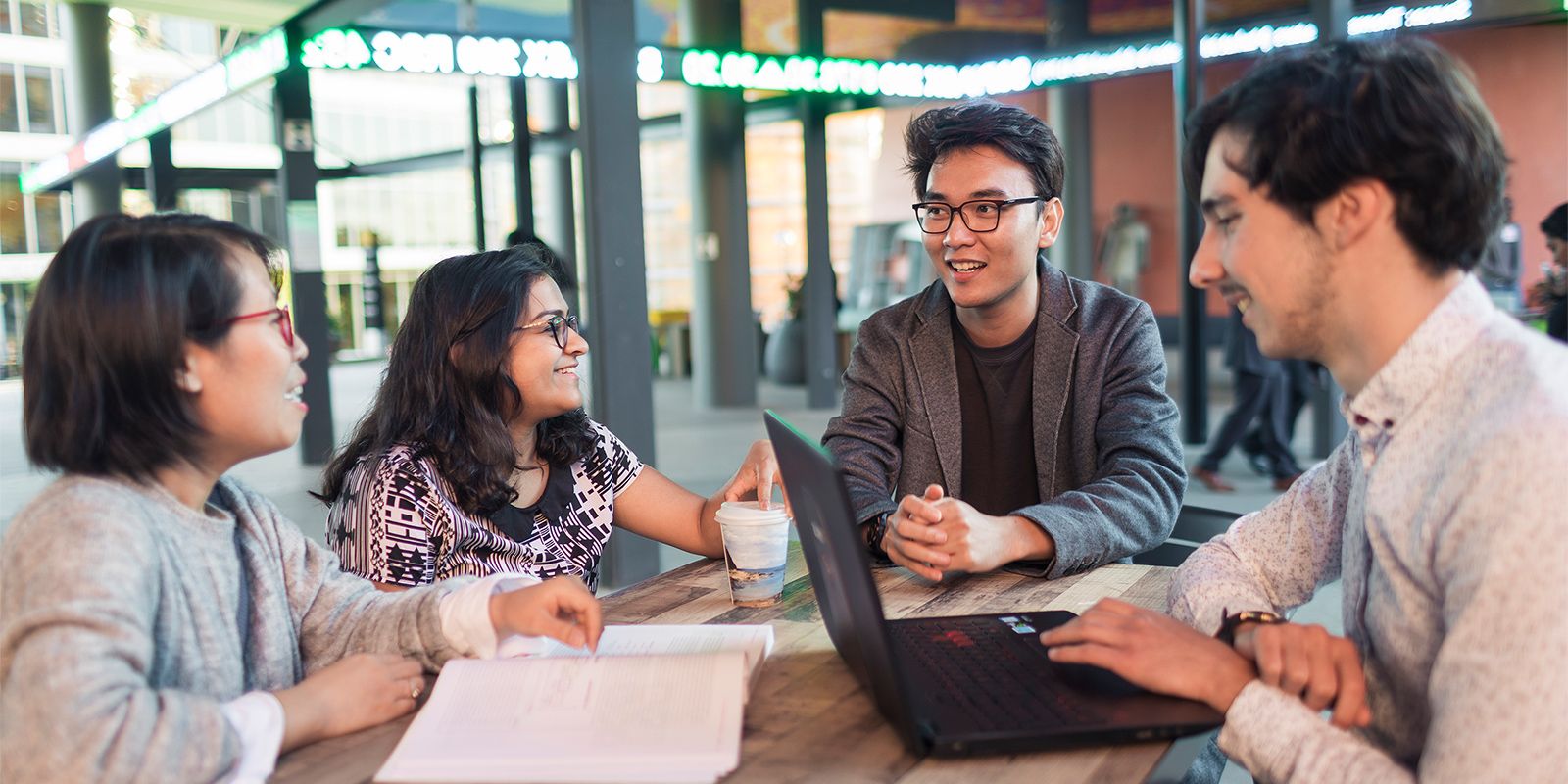 Four students sitting at Westfarmers Court talking