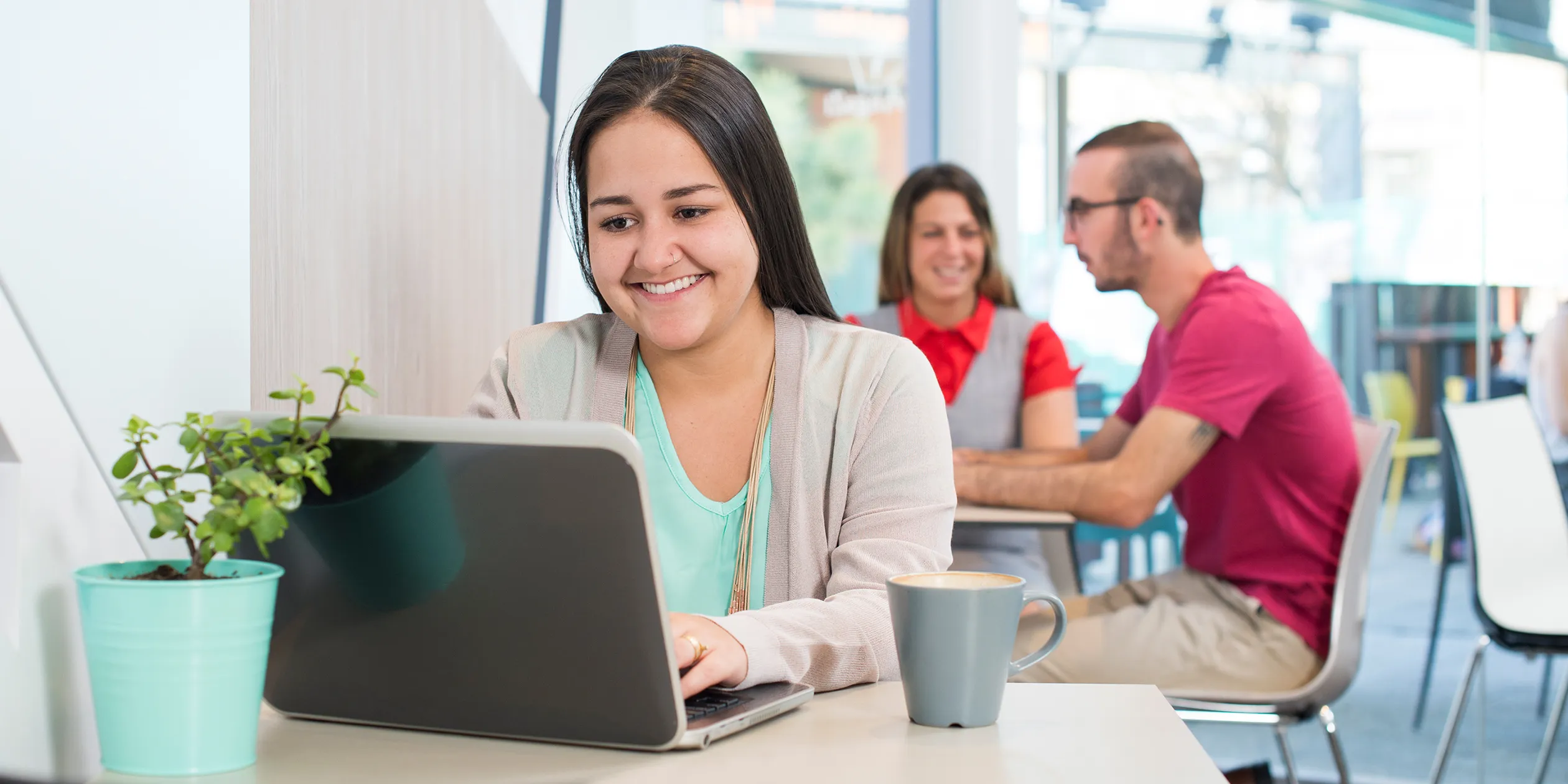 Female student sitting on a laptop in a cafe