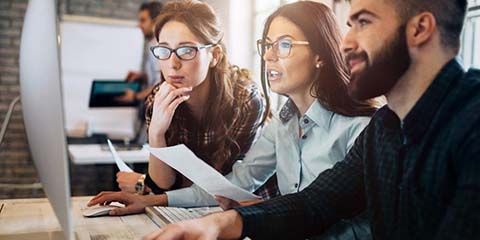 Group of office workers looking at a screen