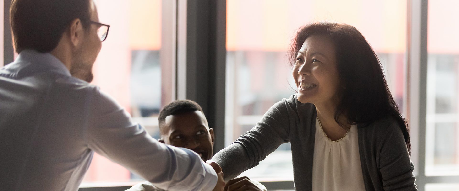 Businesswoman shaking hands with man in glasses