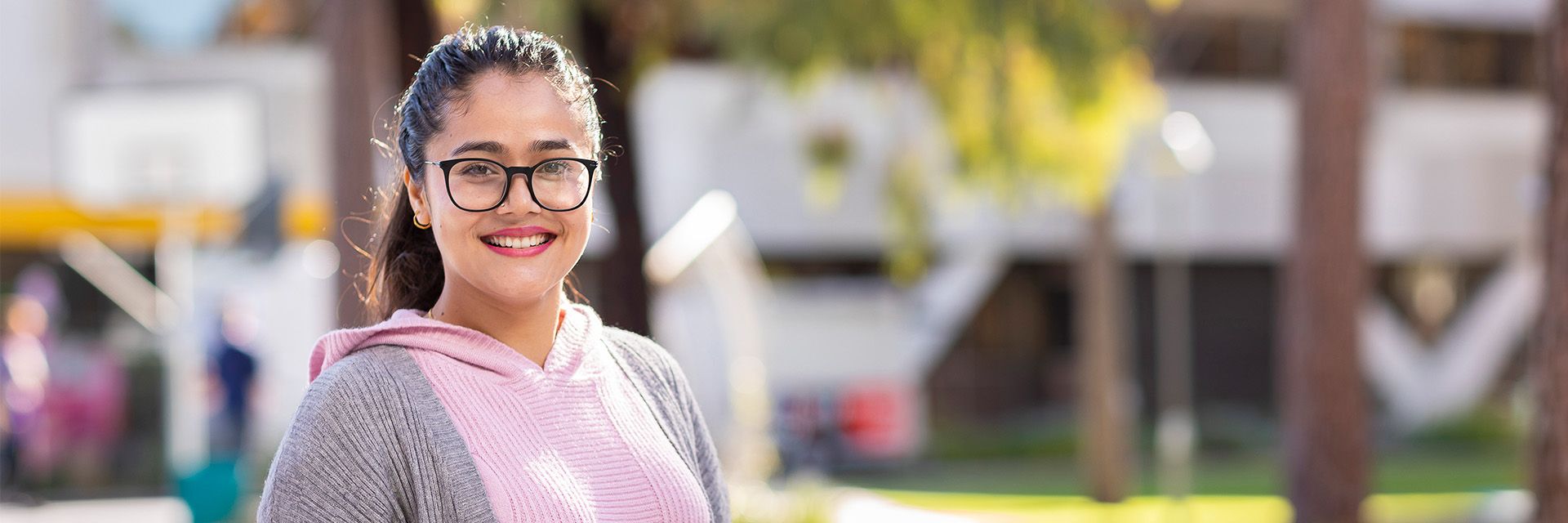 Curtin English student with glasses smiling to the camera