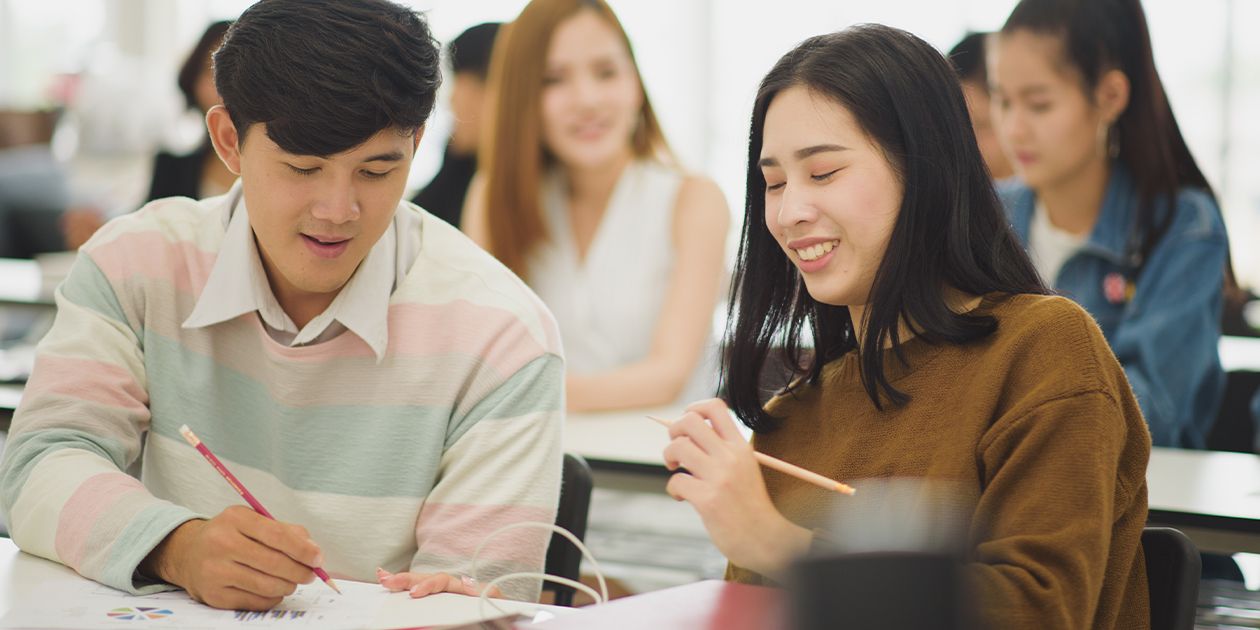 Two students working together in a classroom learning English