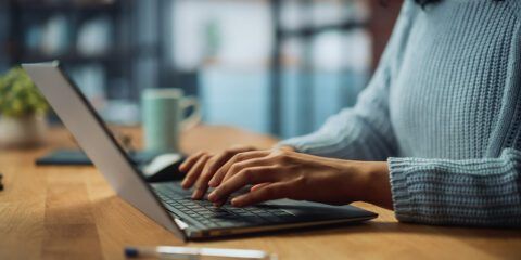 A woman typing on a laptop