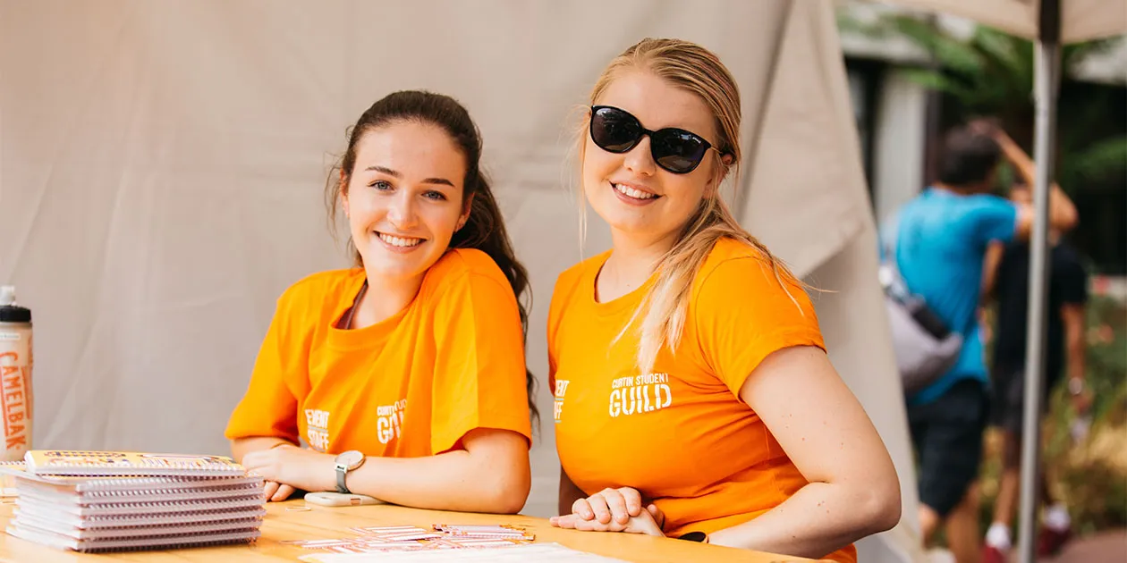 Two students wearing Guild shirts at an event