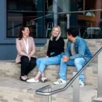 A group of people sitting on the steps of the design building