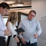 Postgraduate design students speaking with a lecturer - play video